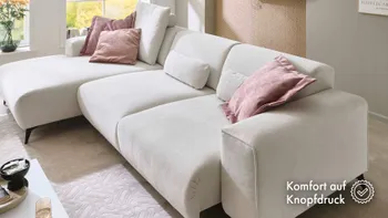 Großes elegantes Sofa mit Longchair in creame weiß, mit rosa Kissen.
